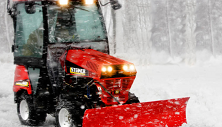 Steiner compact tractor clearing snow with power angle snow plow