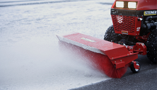 Steiner compact tractor clearing snow with Rotary Sweeper