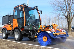 Holder C70 compact tractor cleaning narrow roadway with rotating brush and sprayers