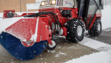 Ventrac snow broom-sweeper clearing snow to dry pavement