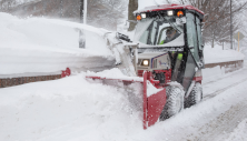 Ventrac 2-stage blower clearing deep snow off sidewalk